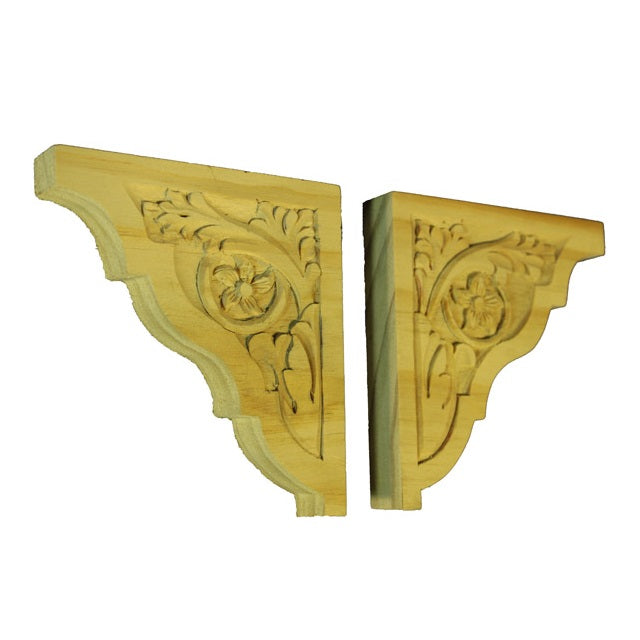 A pair of timber corbels measuring 115x110x19mm each. Flowers and leaves are carved into the corbels.